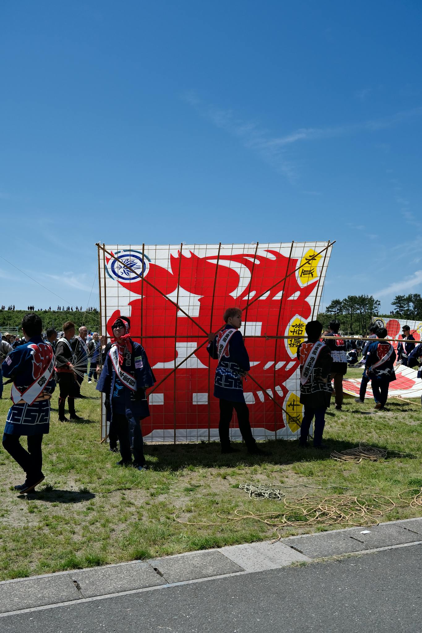 Men prepare large traditional kites at Hamamatsu Kite Festival in Japan.